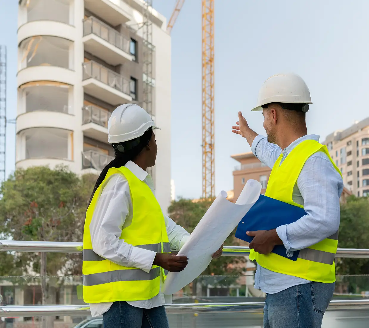 Construction workers discussing building plans onsite.